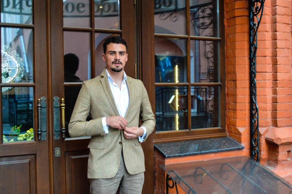 Man wearing a summer custom suit outside of a shop.